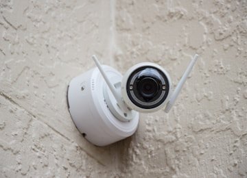 Wall-mounted CCTV surveillance camera monitoring a commercial building perimeter