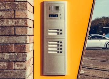 Video doorbell camera and entry intercom unit installed beside a front door