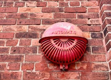 Red fire alarm call point installed as part of a commercial fire detection system